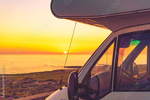 Camper car on sea at sunset