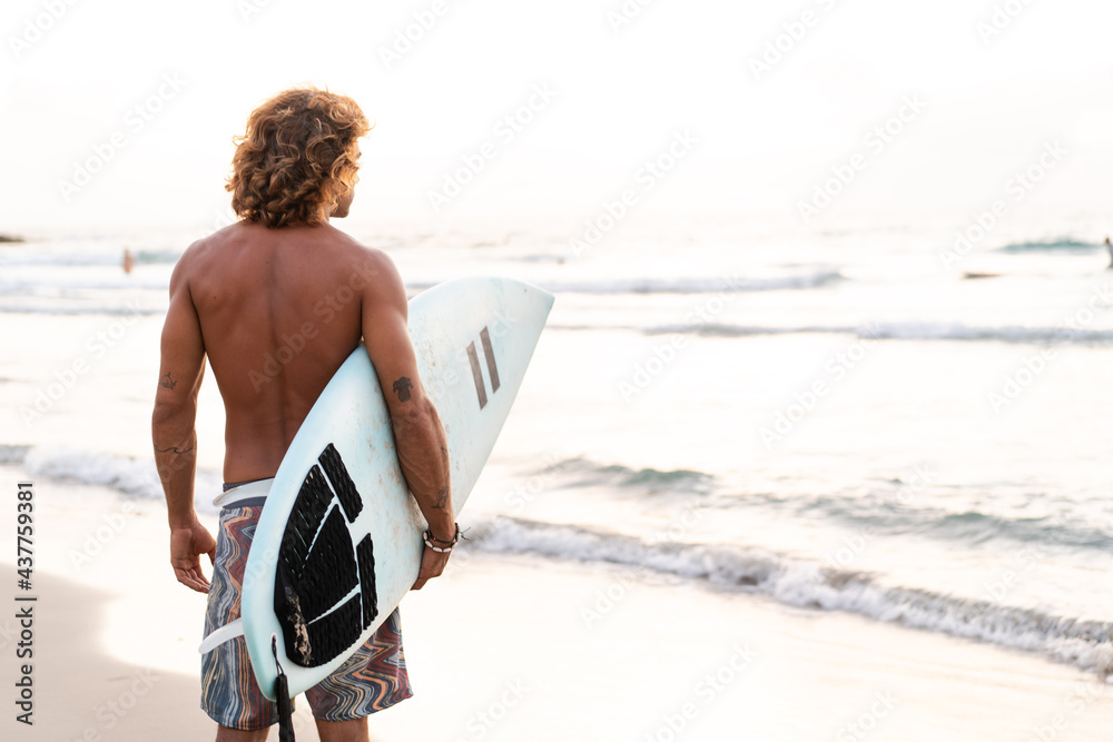 Young caucasian man get up early to  doing surf at sunrise - obrazy, fototapety, plakaty 