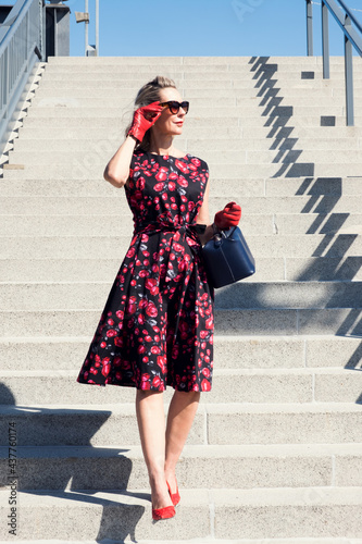 blonde woman in red dress  walking down stairs