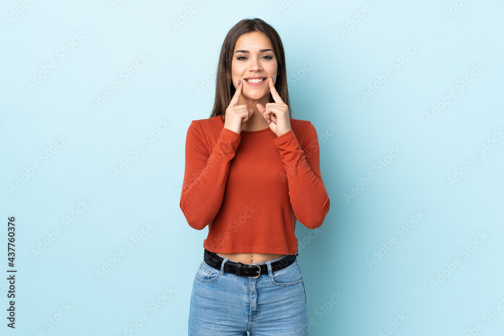 Young caucasian woman isolated on blue background smiling with a happy and pleasant expression Young caucasian woman isolated on blue background smiling with a happy and pleasant expression
