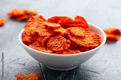 Healthy baked carrot chips in white bowl