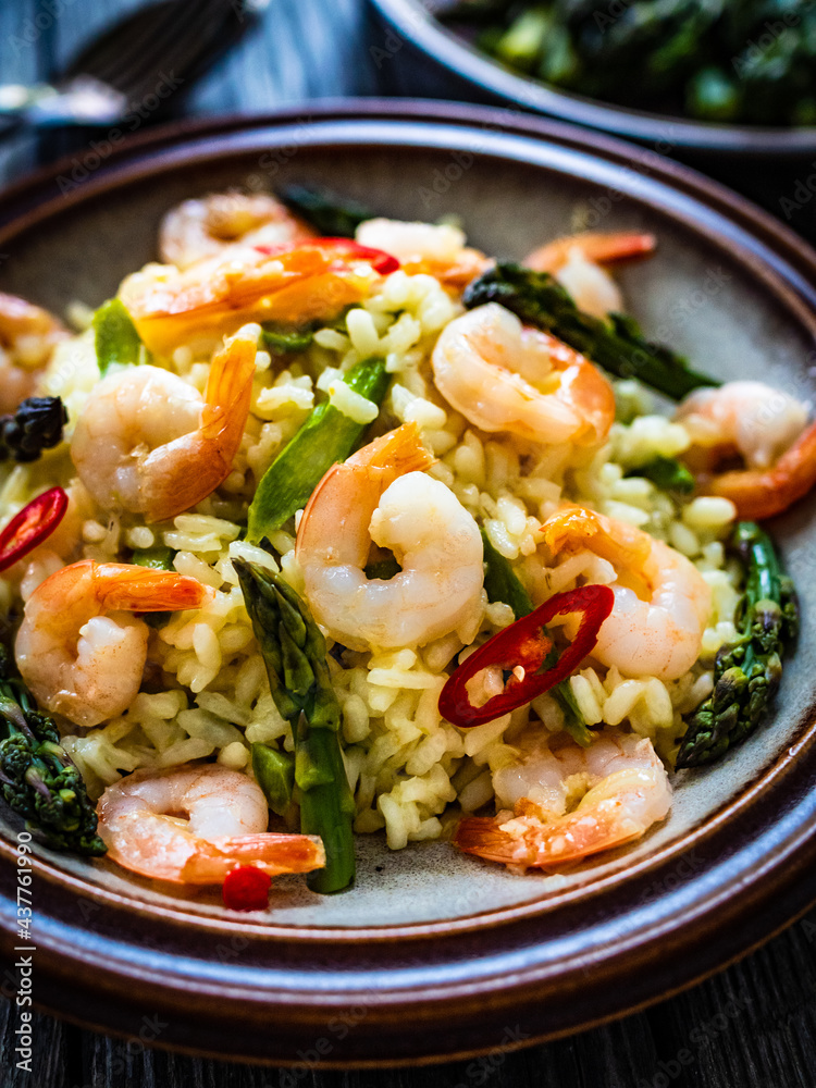 Risotto with prawns and asparagus on wooden background
Risotto with prawns and asparagus on wooden background