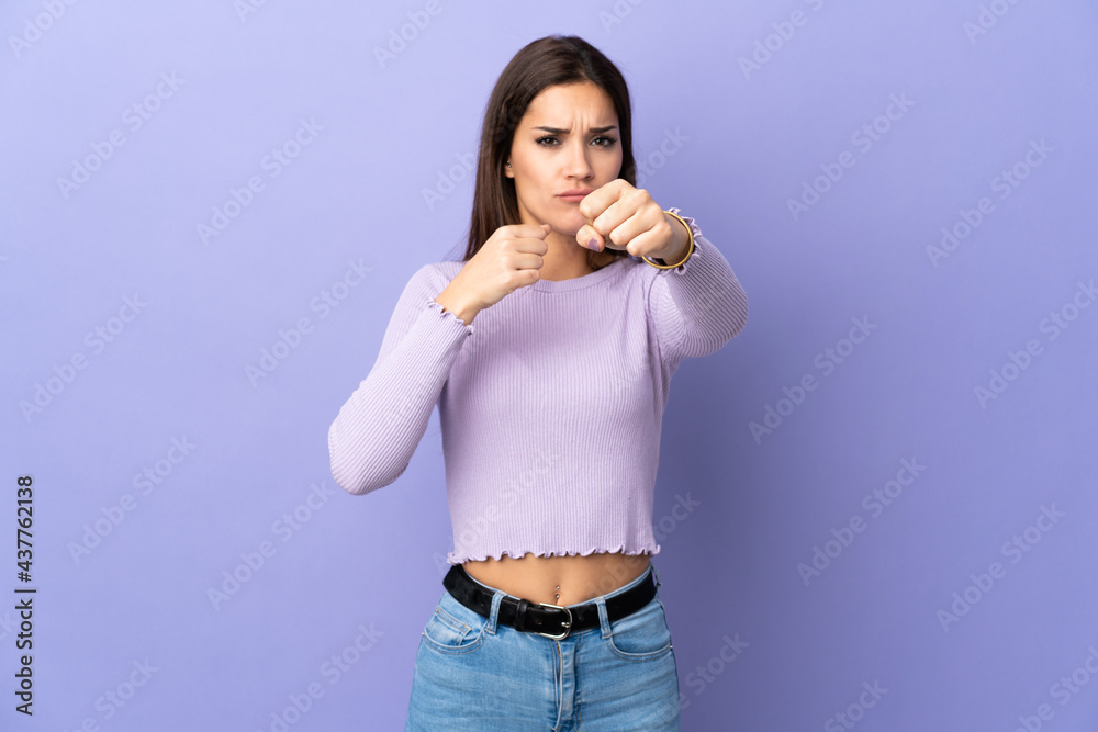 Young caucasian woman over isolated background with fighting gesture Young caucasian woman over isolated background with fighting gesture