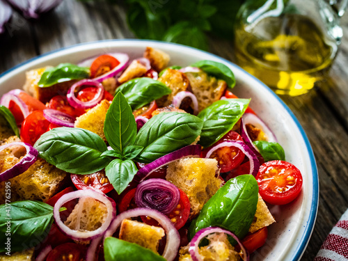 Classic panzanella salad on wooden board

 photo