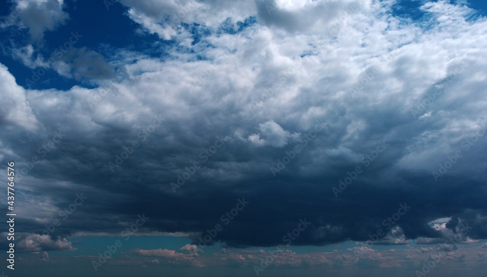 Obraz premium Beautiful contrasting large clouds in blue sky for background