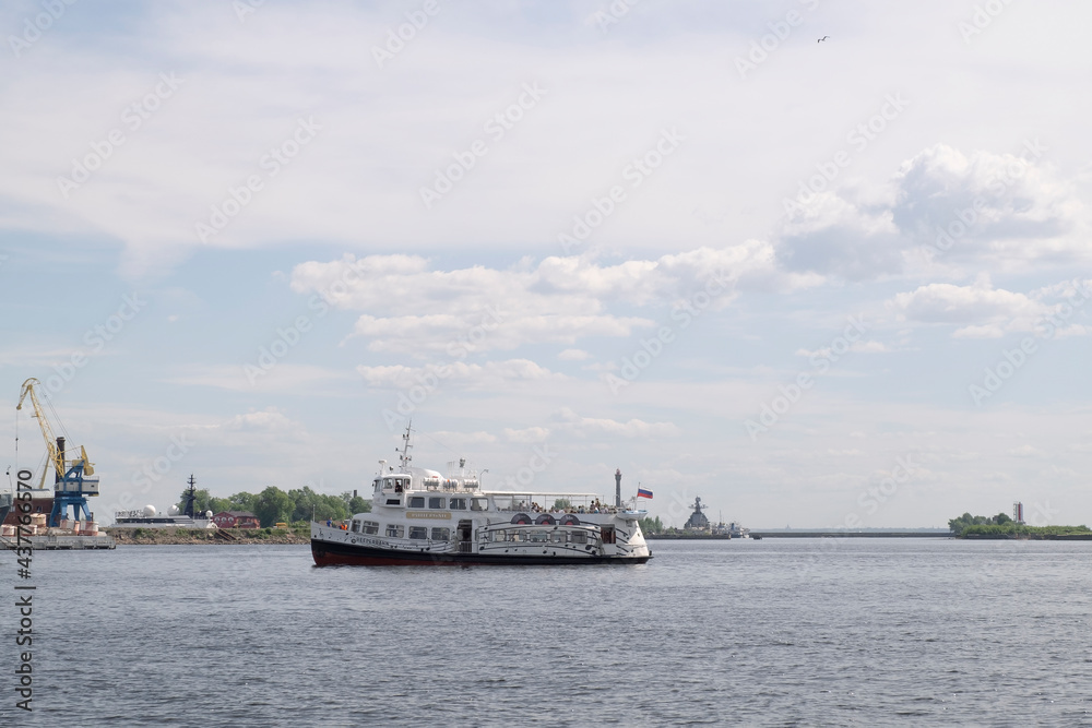 Kronshtadt, St. Petersburg, Russia - June 06, 2021 A pleasure boat with tourists arrives at the pier in the harbor. Selective focus. Kronshtadt, St. Petersburg, Russia - June 06, 2021 A pleasure boat with tourists arrives at the pier in the harbor. Selective focus.