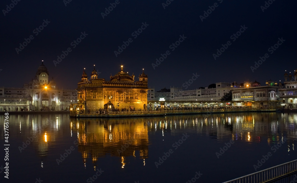 Amritsar, India : Wide angle shot of Harmindar Sahib, aka Golden Temple Amritsar. Religious place of Sikhism. Sikh gurdwara in the holy pond at night with reflection