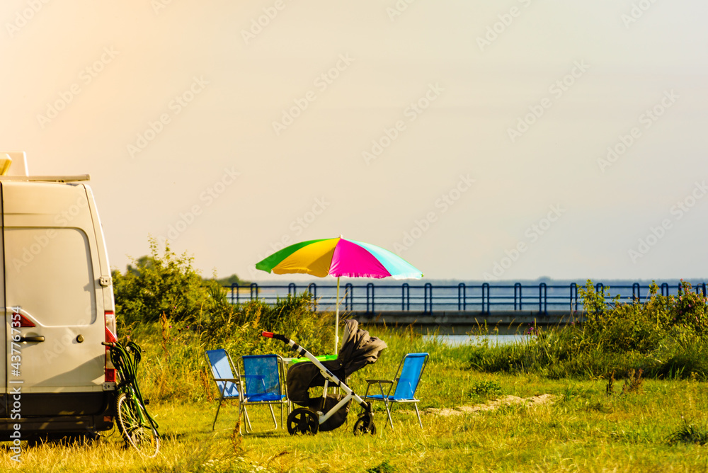 Umbrella with chairs at campervan on beach