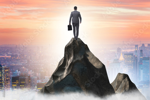 Businessman at the top of mountain in career concept