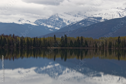Mountain and forest trees reflected in lake