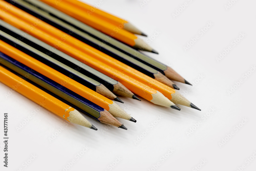 few sharply sharpened pencils of different color on the white table. selective focus few sharply sharpened pencils of different color on the white table. selective focus