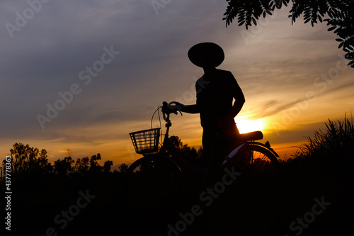 Silhouette of man and Bicycle.A man at sunset on grass field meadow.Sports outdoor activities  Healthy Lifestyle.Photo concept of Silhouette and Sport.