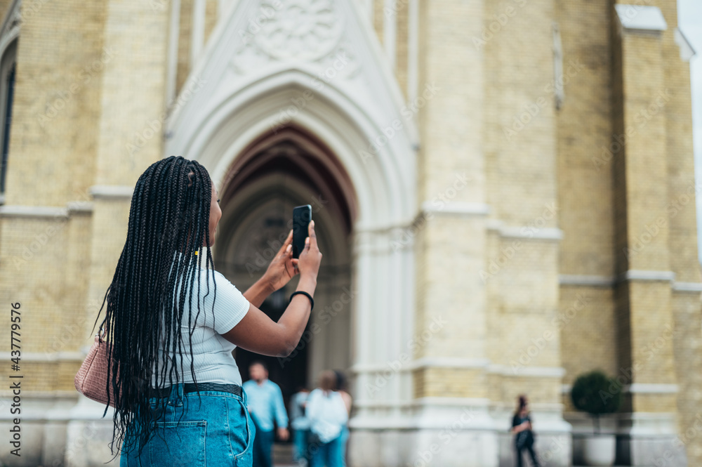 Cheerful african american woman using smartphone and taking photo