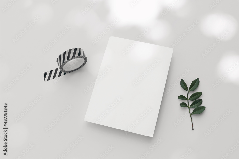 Summer wedding stationery mock-up. Blank greeting card, striped washi tape and green leaf invitation on white table backgound in sunlight. Natural light and shadow overlay. Flat lay, top view. Summer wedding stationery mock-up. Blank greeting card, striped washi tape and green leaf invitation on white table backgound in sunlight. Natural light and shadow overlay. Flat lay, top view.
