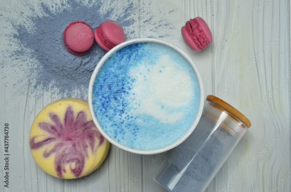 blue matcha in a white cup on white wooden table