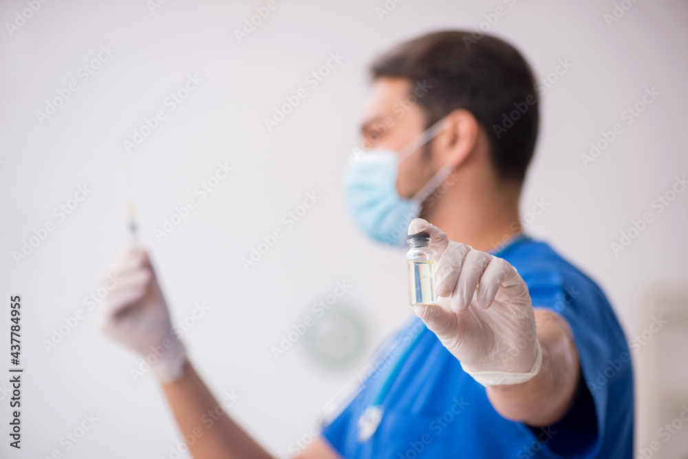 Young male doctor in vaccination concept during pandemic Young male doctor in vaccination concept during pandemic