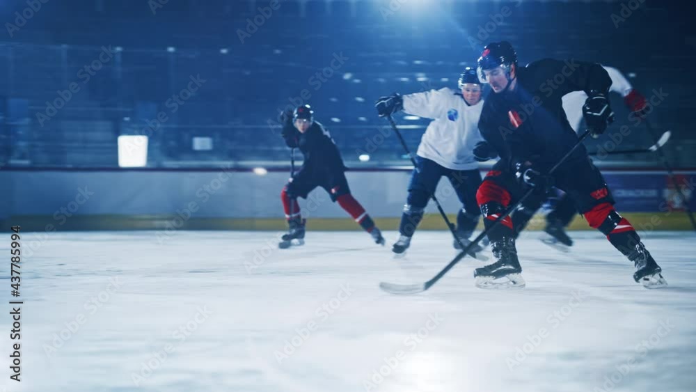 Ice Hockey Rink Arena: Professional Forward Player Breaks Defense, Hitting Puck with Stick Scores Goal, Goalie Missed it. Two Competitive Teams Play. Cinematic Slow Motion Tracking Wide Profile