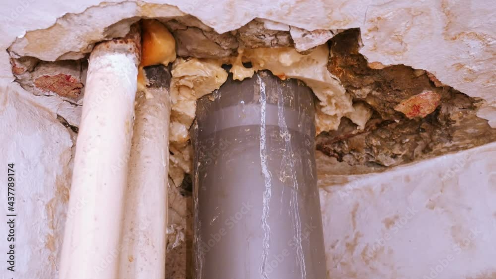 Leaking sewer pipe in the bathroom ceiling. A destroyed ceiling with