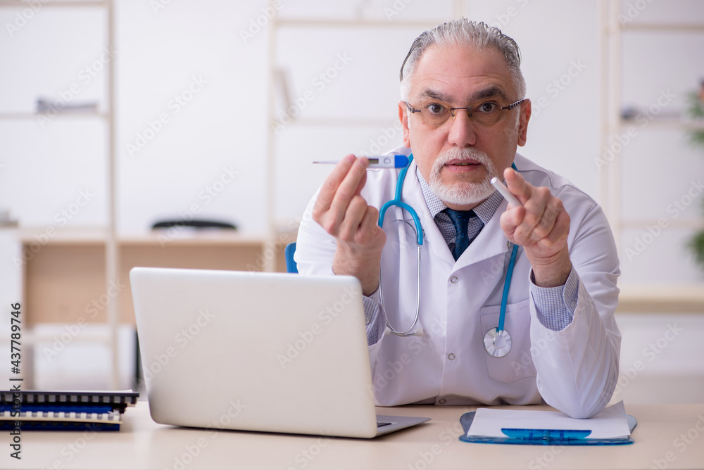 Old male doctor working in the clinic Old male doctor working in the clinic