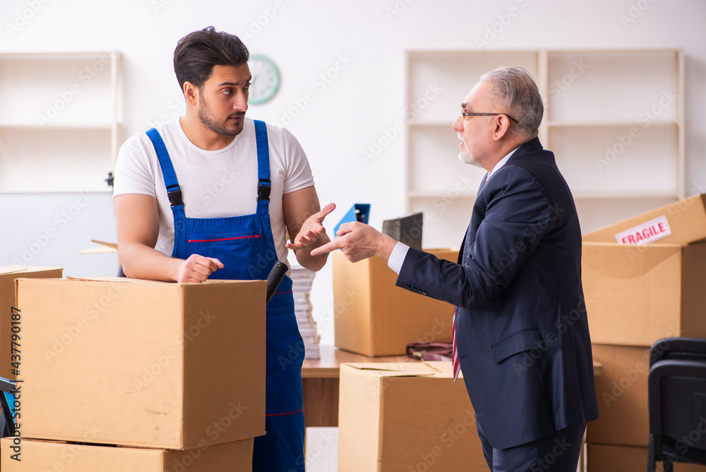 Old businessman and young contractor in relocation concept Old businessman and young contractor in relocation concept
