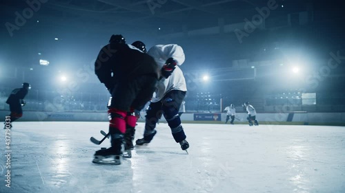 Ice Hockey Rink Arena: Young Players Training, Learning Stick and Puck Handling. Athletes Learn how to Dribble, Attack, Defend, Protect, Possesion, Drive the Puck. Cinematic Slow Motion Shot photo
