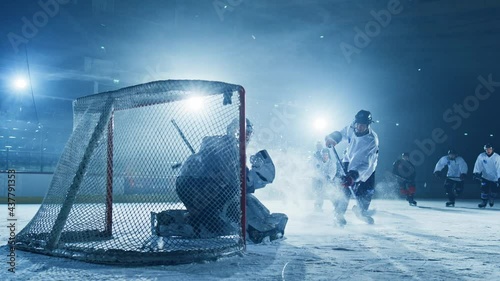 Ice Hockey Rink Arena: Goalie against Forward Player who Does Slapshot, Shots Puck with Stick and Scores Goal. Forwarder againstGoaltender.Team Celebrates. Cinematic Slow Motion Behind Goals Wide Shot photo