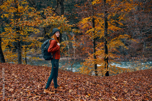a traveler with a backpack walks in the park in nature near the river in autumn © SHOTPRIME STUDIO