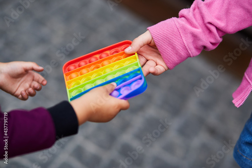 Rainbow sensory fidget. Colorful antistress sensory toy fidget push pop it in children's hands. Antistress trendy pop it toy. New trendy silicone toy. High quality photo