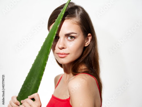 portrait of a beautiful woman with green aloe leaf near the face clean skin cosmetology dermatology