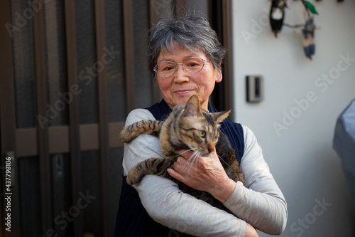 Canvas Print Portrait of an old Asian lady holding a brown patch cat in Japan.