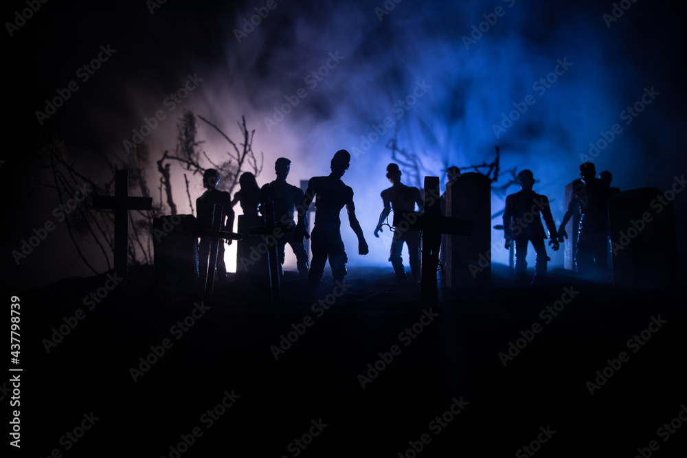 Scary view of zombies at cemetery dead tree, moon, church and spooky cloudy sky with fog, Horror Halloween concept with glowing pumpkin. Selective focus