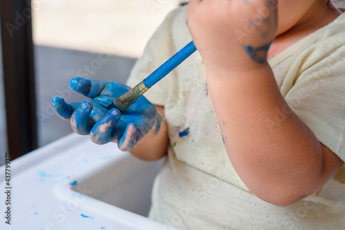 The baby paints his hand