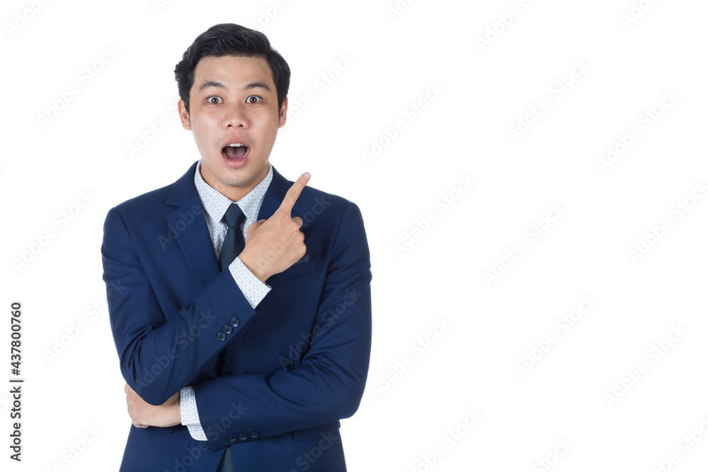 Young attractive asian business man wearing navy blue suit with white shirt and necktie smiling and looking surprised and point his finger up. White background isolated Young attractive asian business man wearing navy blue suit with white shirt and necktie smiling and looking surprised and point his finger up. White background isolated