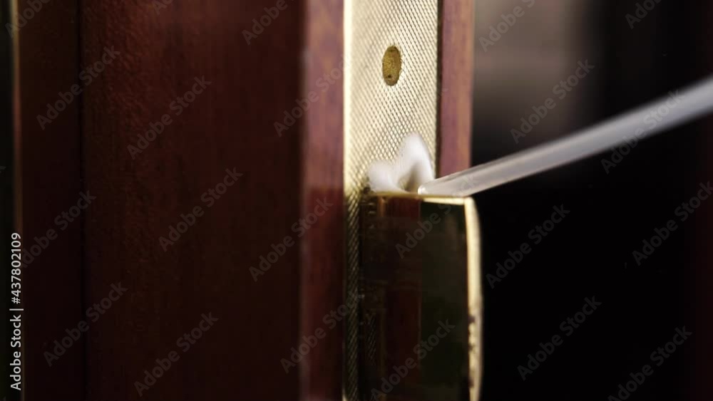 Lubricating the door lock with liquid oil. Macro shot. Spraying under pressure from a plastic tube in slow motion. Household chores concept Lubricating the door lock with liquid oil. Macro shot. Spraying under pressure from a plastic tube in slow motion. Household chores concept
