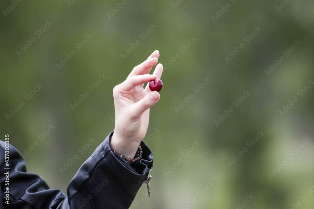Fototapeta premium person holding a cherry 