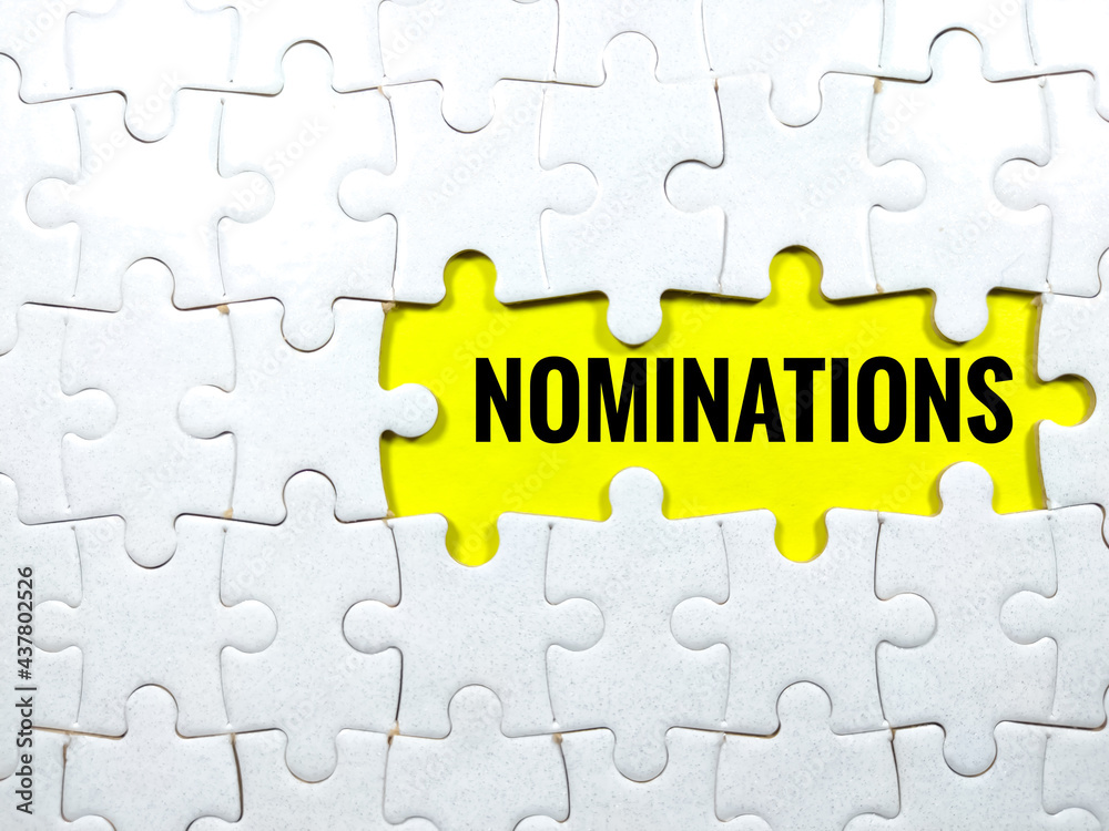 Selective focus.Text NOMINATIONS with jigsaw puzzle on yellow background.