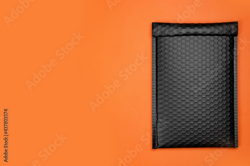 Bilde på lerret Padded envelope with bubble wrap on orange background, top view