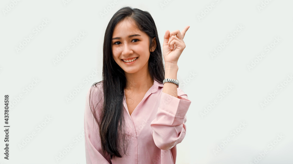 Half-length portrait of pretty female showing index finger and smiling in white background Half-length portrait of pretty female showing index finger and smiling in white background