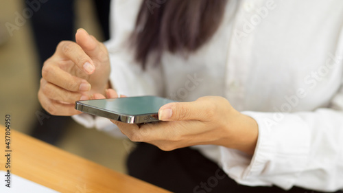 Female hands using smartphone  texting message on the phone in workplace