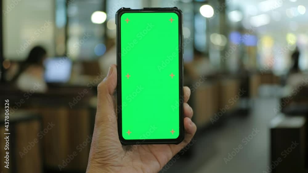 Man hand holding smart phone with chroma key green screen display ...