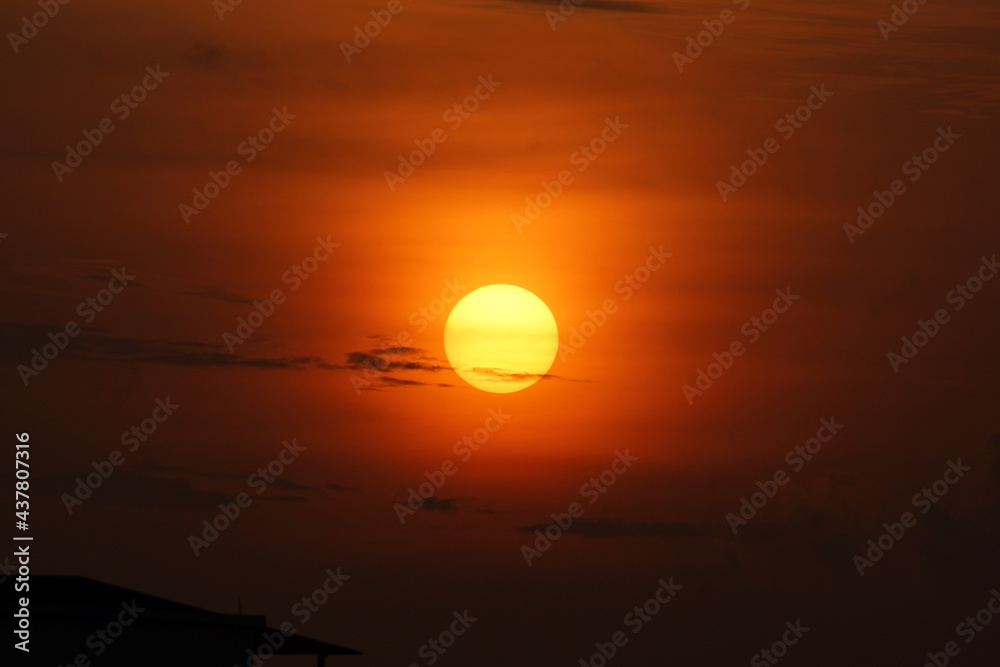 Fototapeta premium Early morning yellow color sun with orange sky and black clouds