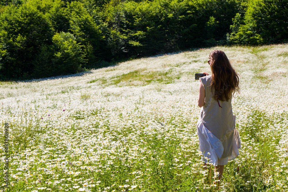 Women with dress in field of daisy flowers
