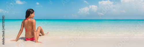 Beach vacation banner panoramic background of bikini woman relaxing sunbathing on idyllic winter getaway holidays on Caribbean island.