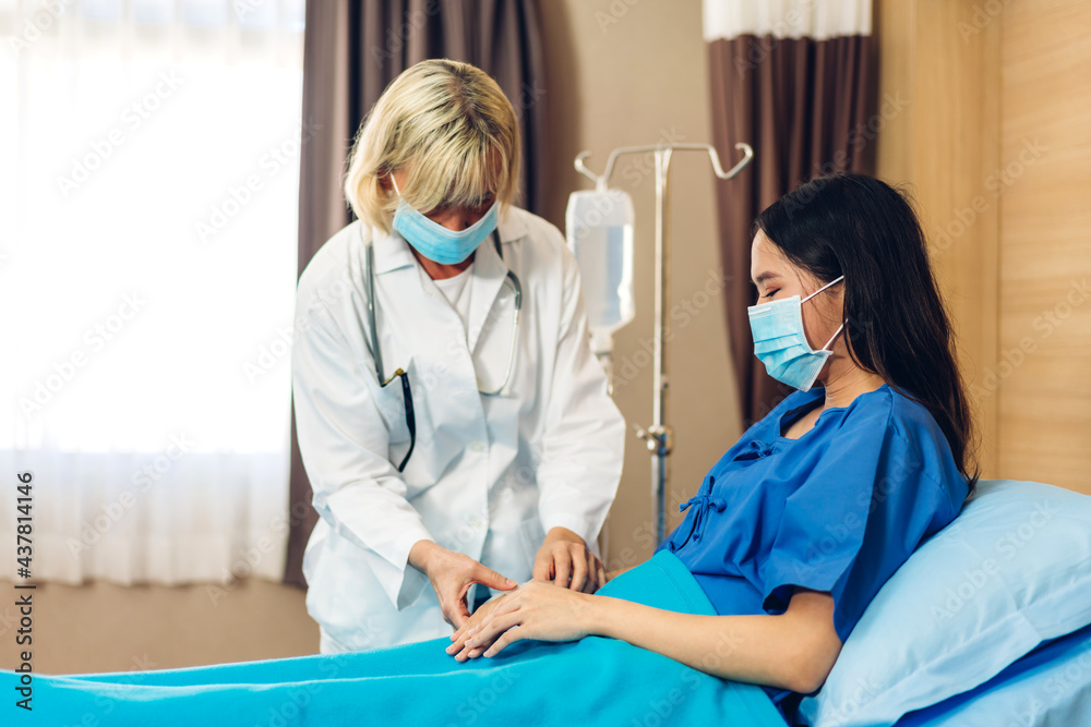 Fototapeta premium Senior woman doctor wearing protective mask with stethoscope service help support discussing and consulting talk to sick woman patient about checkup result information in hospital