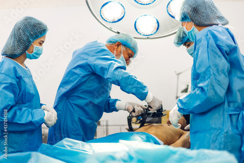 Professional anesthesiologist doctor medical team and assistant preparing patient to gynecological surgery performing operating with surgery equipment in modern hospital operation emergency room