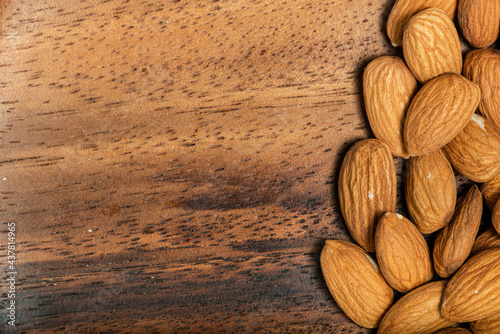 Almonds isolated on wooden background. Top view. Macro photography