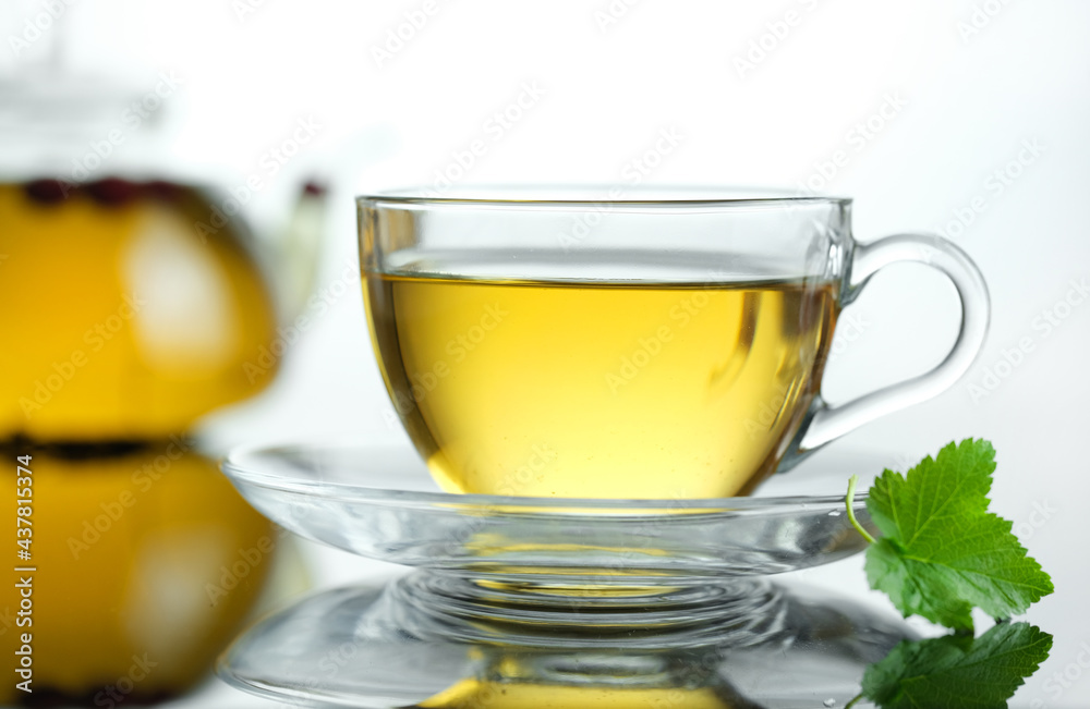 Yellow herbal tea in glass cup with leaf. Close-up cup of freshly brewed hot tea. Yellow herbal tea in glass cup with leaf. Close-up cup of freshly brewed hot tea.