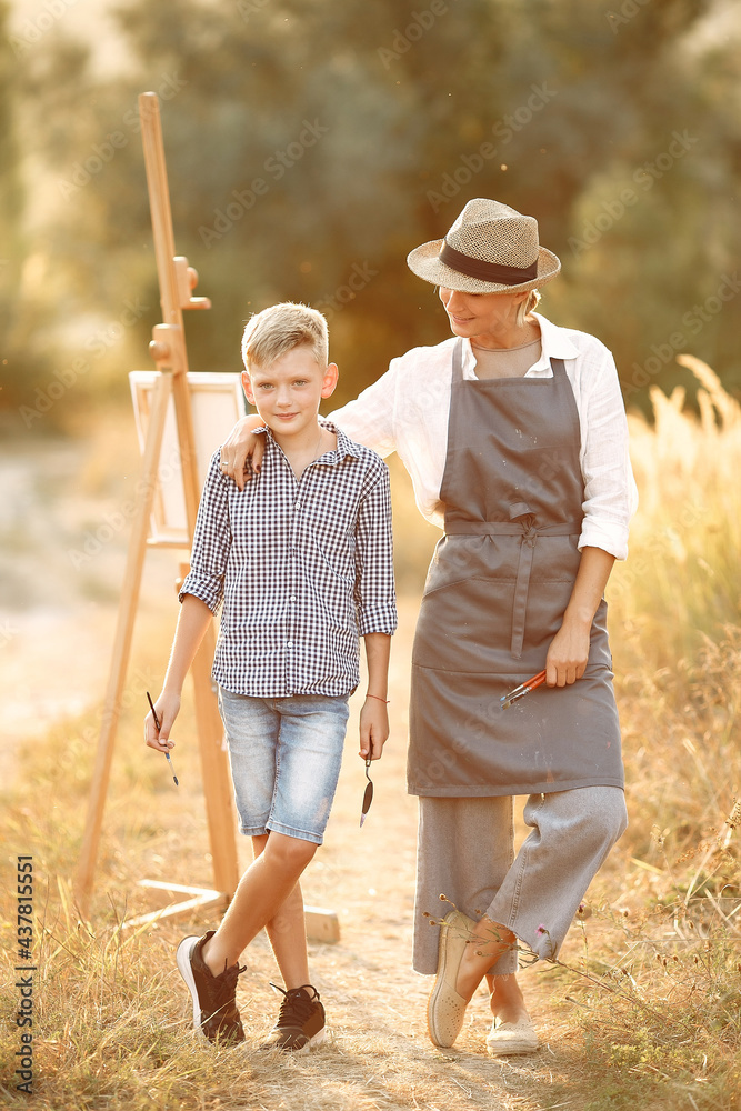 Mother with son painting in a field