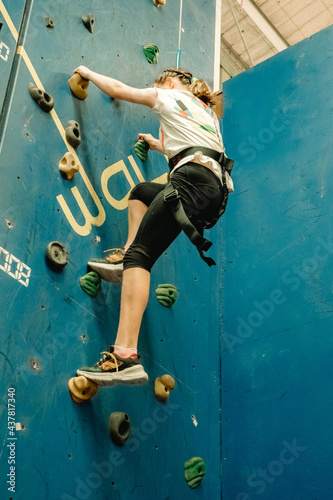 young child girl on indoor climbing wall, bouldering