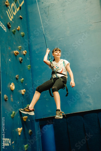 young child girl on indoor climbing wall, bouldering